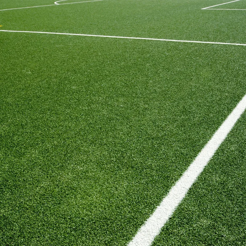 Close-up of green artificial turf with a white line marking