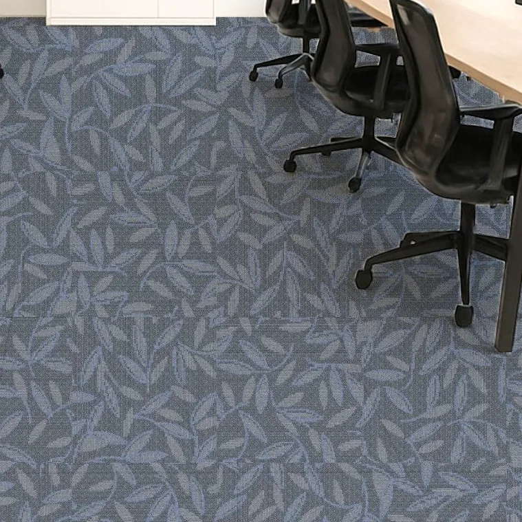 Black office chairs and desks on a blue broadloom carpet with a scattered leaf pattern