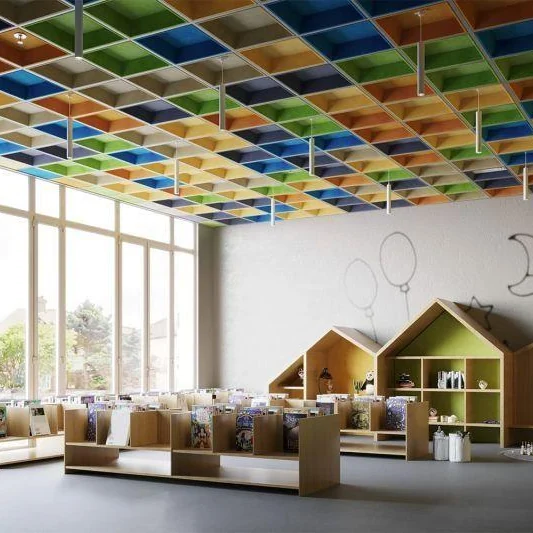 Children's library with low benches and house-shaped bookshelves under a ceiling grid of blue, green, yellow and orange acoustic panels