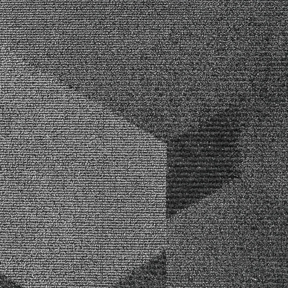 Close-up of grey carpet tiles with a subtle geometric pattern meeting at a straight joint