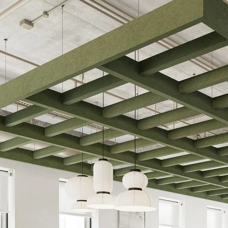 Olive green acoustic ceiling grid suspended below an exposed concrete slab, with white pendant lights hanging through it