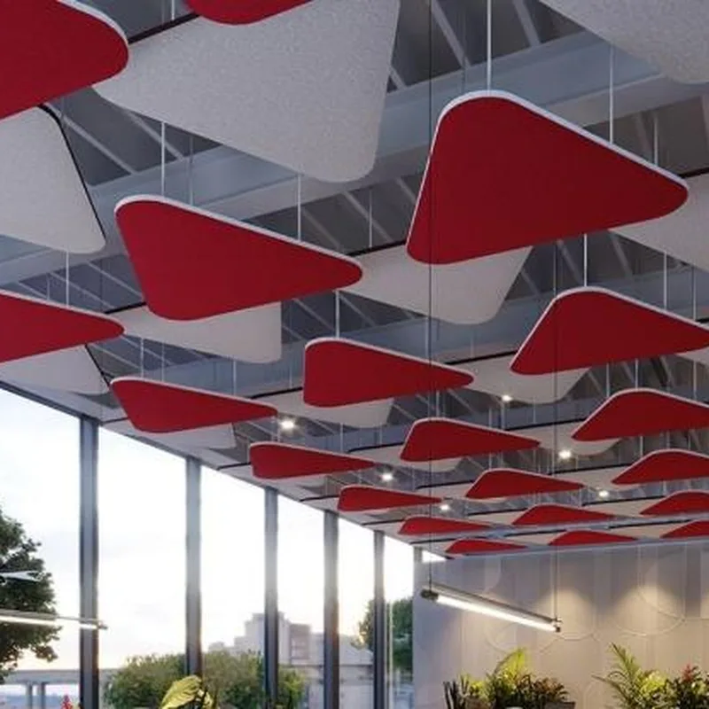 Rows of red and grey triangular acoustic clouds hung below a glazed atrium roof