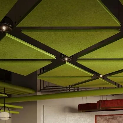 Green triangular acoustic ceiling panels in a dark grid above red bench seating