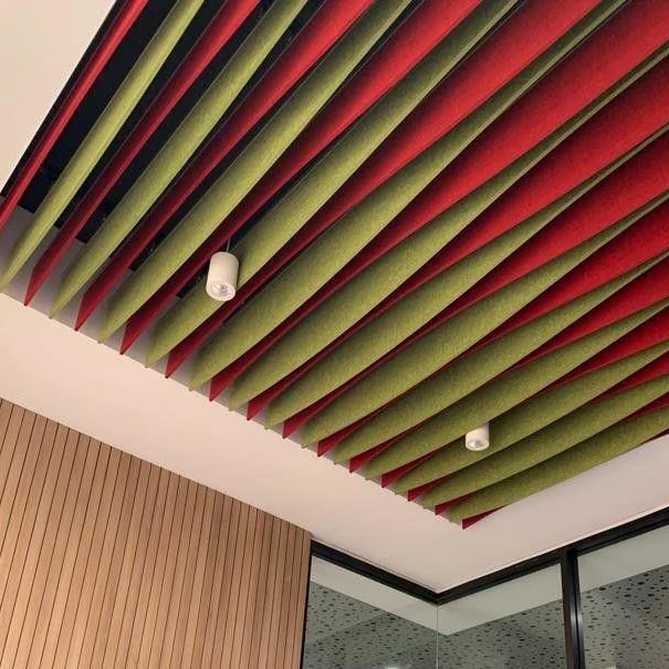 Ceiling of long acoustic baffles in stripes of green, red, yellow and grey above timber wall panelling